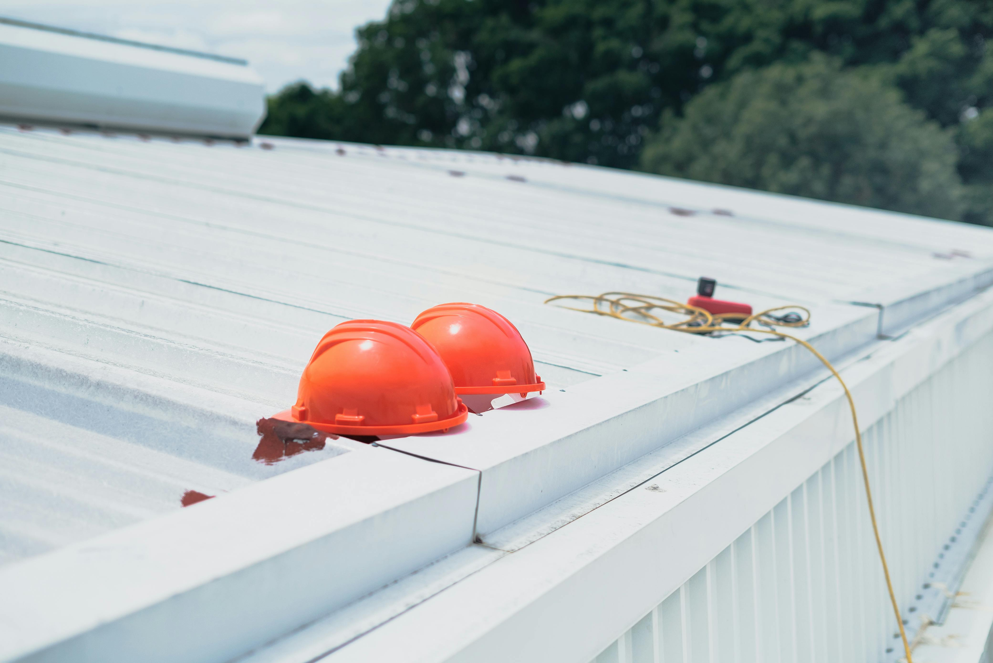 Two red helmets on a white wooden fence